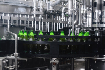 The process of filling beer into bottles on a production conveyor line