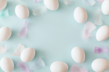 Fototapeta premium White Easter eggs and feathers on pastel blue background. Top view, flat lay, copy space