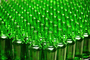 Rows of new empty green glass bottles. on the production line. Industrial beer production