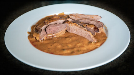 cooking at home and healthy food from a hunt of a roe deer - roasted venison from a roe buck in pepper sauce 