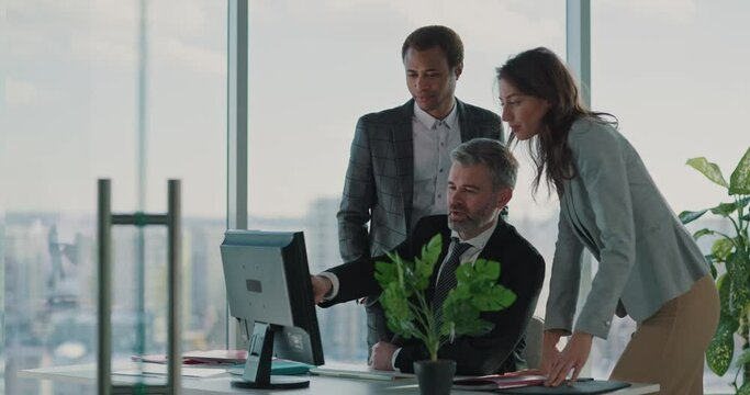 Collaborative team of businessmen and office manager woman using compiuter browsing project solving issues cooperating in start-up company.