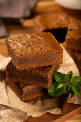 Chocolate brownies stacked with mint leaves.