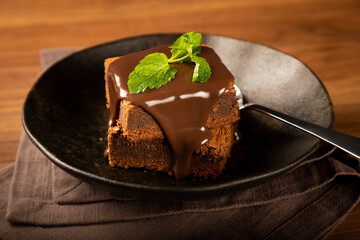Chocolate brownies with chocolate sauce and mint leaves