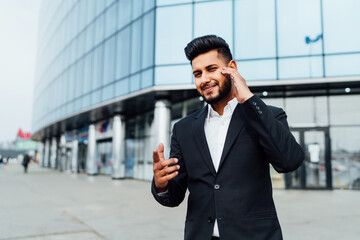Portrait of a smiling bearded Indian, Asian appearance, he looks at the camera and points at you