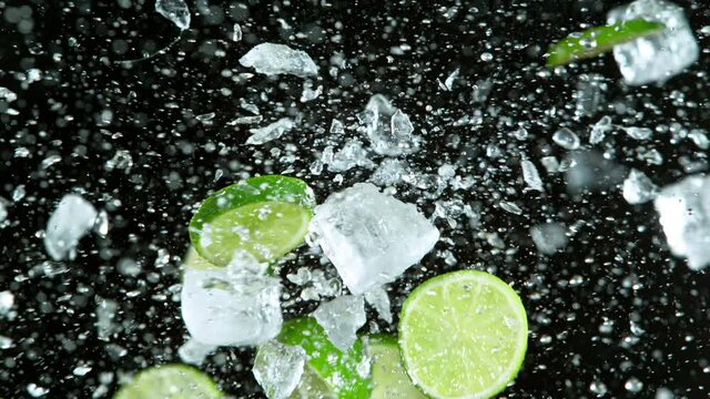 Super Slow Motion Shot of Fresh Limes Collision with Ice Cubes nad Splashing Water. Filmed on high speed cinema camera at 1000fps.