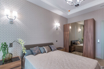 Classic interior of the bedroom with a wooden wardrobe