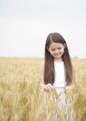Cute child has fun outdoors. Little cute girl posing in the meadow.