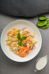 Pasta with shrimps in a creamy sauce on a plate with spinach