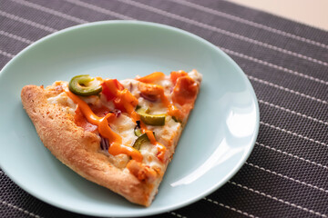A slice of pizza on a gray plate. Top view.