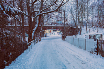 Straße im Winter bei Schnee vor Bahndamm Tunnel Unterführung