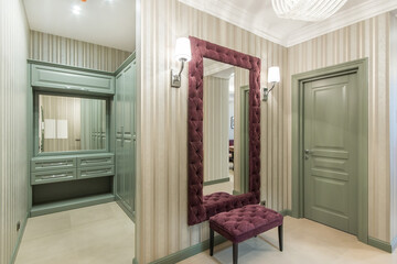 The classic olive built-in wardrobe in the corner of the hall. A mirror hanging in front of the...