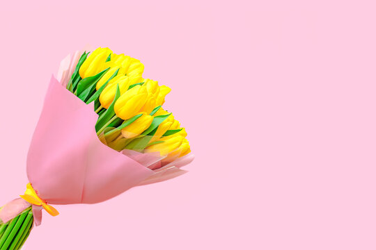 beautiful  spring bouquet of yellow tulips on a pink background. .The concept of the celebration. Greeting card. Flat lay, top view.