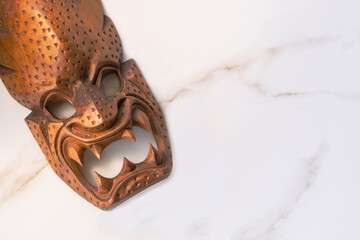 Part of Japanese antique wooden carving Noh mask on white marble tabletop, flat lay with copy space