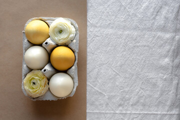 Colored eggs and flowers in the eggshell. Easter rustic background.