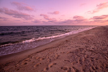 Early morning on the beach. Pink purple sunrise over the sea. Pastel color