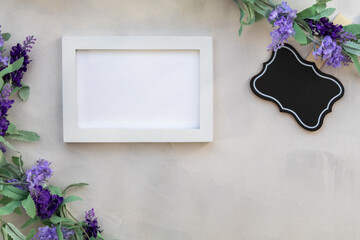 White frame mockup and lilac on gray wash background flat lay copy space