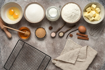 Fototapeta na wymiar Baking background. Baking ingredients: flour, eggs, sugar, honey, butter, milk and spices on grunge background. Top view.