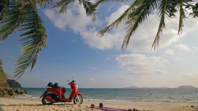 The red motorbike on forest road trail trip, sea. One scooter, near tropical palm tree. Asia Thailand ride tourism. Single motorcycle, rent. Ocean, white sand and tropical palm tree. Safety helmet.