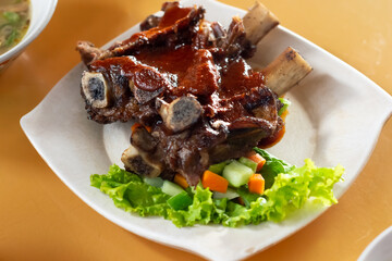 grilled beef ribs on white plate in the table