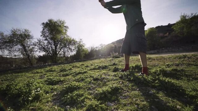 Joven agricultor cava agujero en el huerto con una azada con calidad cinematogr&aacute;fica