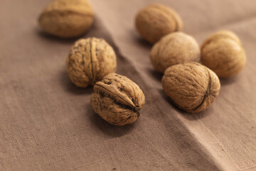 Seven pieces of whole walnuts on a brown kitchen towel