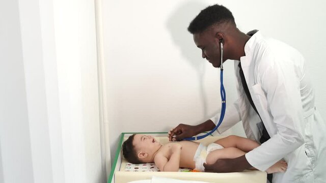 Newborn baby get examine by pediatrician hold stethoscope, pediatric doctor monitoring heart pulse rate adorable infant in clinic, pediatrician with child concept.