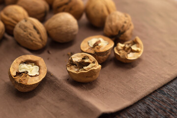 Fresh walnuts whole and chopped lie on the table on a kitchen towel