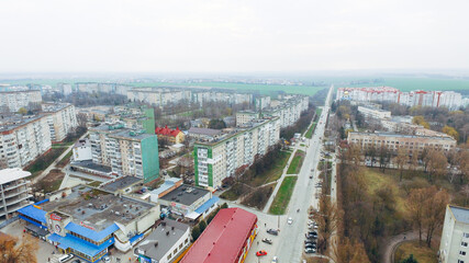 Aerial view of a small town, green fields, park, highways against the sky. Ukraine
