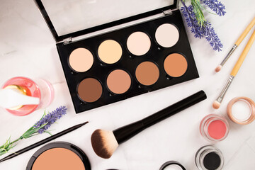 Beige pastel shades palette for contouring, highlighter and tone of the face, brushes, nude makeup