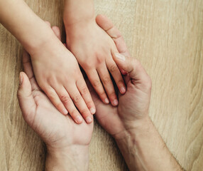 children's hands in the hands of adults