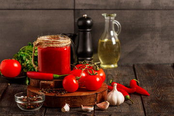 Salsa Sauce. Spicy, colorful Mexican salsa sauce with hot peppers and tomatoes on a dark background.Classic homemade Italian tomato sauce  for pasta  pizza in  on wooden background.
