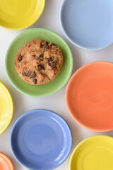 Lone cookie Colorful empty plates