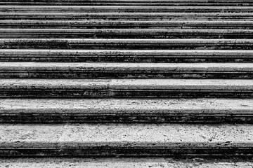 Old medieval craggy uneven grungy stepping street of downtown Europe city.Italy grand front staircase of aged rough cement granite blocks.Dirty cracked chipped grooved tuff surface of 3D grunge design
