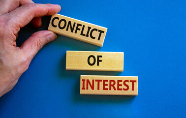 Conflict of interest symbol. Wooden blocks with words 'conflict of interest'. Beautiful blue...