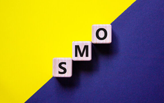 SMO, social media optimization symbol. Wooden cubes with word 'SMO - social media optimization' on beautiful yellow and blue background, copy space. Business, SMO - social media optimization concept.