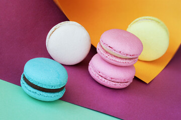 Fototapeta na wymiar Bright colorful macarons of different tastes close-up on multicolored background, gourmet gift