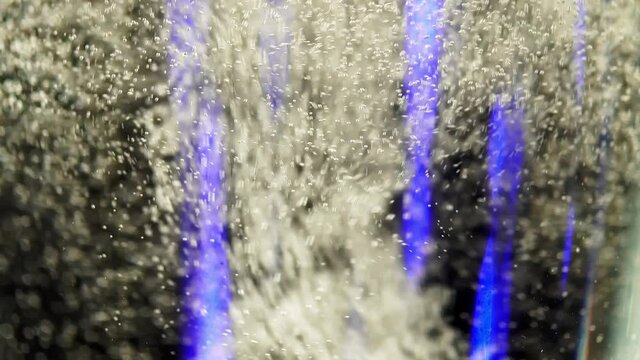 Macro view of sparkling wine with bubbles in a transparent glass. Jib footage of a bocal with champagne. Closeup of a delicious alcohol drink. An elegant celebration of romantic holiday or lovely date