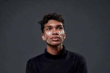 Portrait of young guy with lettering on his face
