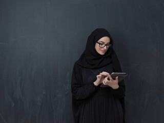 Young Arab businesswoman in traditional clothes or abaya with tablet computer