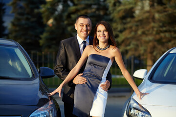 portrait of a young couple on a date standing near cars. - 419700488
