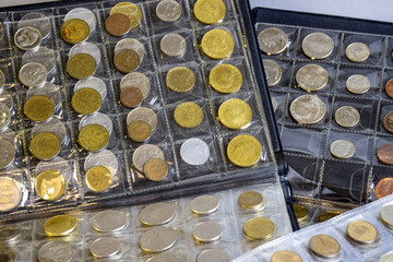 Сoins are arranged in transparent blisters. Page from album full with old coins . Coin storage method. Numismatic collection. Focus in background. Close-up. Copy space.