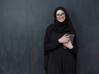 Young Arab businesswoman in traditional clothes or abaya with tablet computer