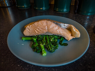 Steamed salmon and broccoli on a blue plate