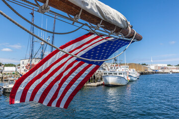 USA, Massachusetts, Cape Ann, Gloucester. Gloucester Schooner Festival, schooner masts and US flag.