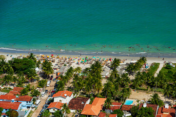 Naklejka na ściany i meble Maria Farinha beach, Olinda, near Recife, Pernambuco State, Brazil on November 15, 2012. Aerial view of the beach with colorful parasols and countless people on the beach.