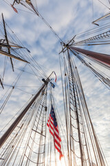 Fototapeta premium USA, Massachusetts, Cape Ann, Gloucester. Gloucester Schooner Festival, schooner masts and US flag.