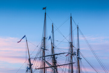 Fototapeta premium USA, Massachusetts, Cape Ann, Gloucester. Gloucester Schooner Festival, schooner masts at dusk.