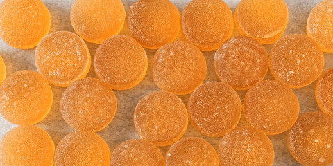 Background texture of orange round sugar coated jelly candies.