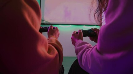 friends are playing video games at home, fighting by joysticks