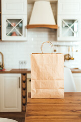 Eco shopping paper bag on the table in modern kitchen. Food delivery or market shopping concept.